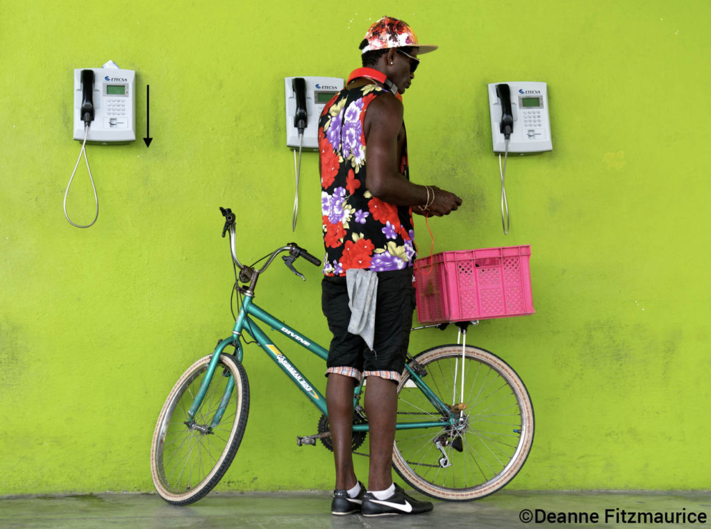 image deanne fitzmaurice - man with bicycle standing in front of green wall, cuba
