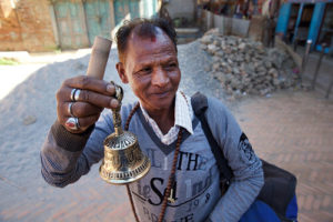 old man from Nepal or Buhtan holding a bell