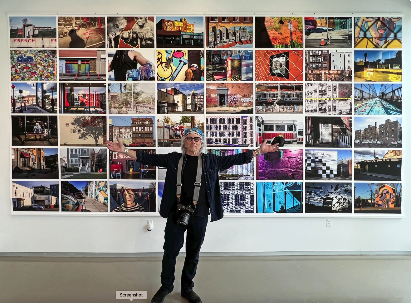 Edward Boche in front of wall of photos