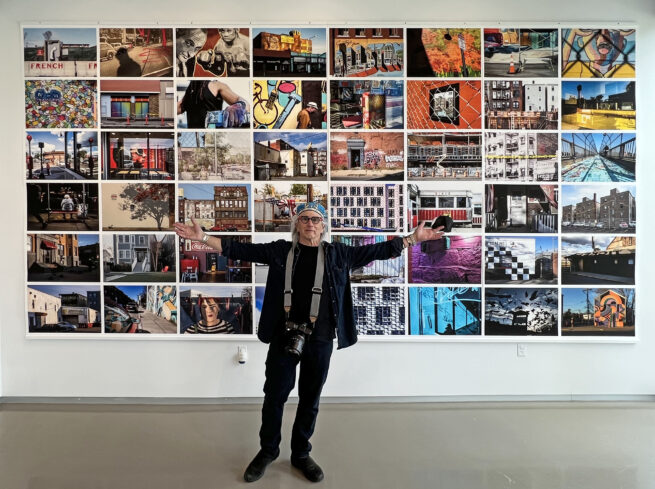 Edward Boches in front of a wall of his images hung with DSI Wood Print Hangers.