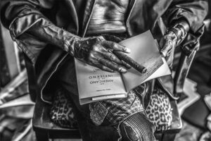 Mathieu Bitton image of hands holding a book and cigar