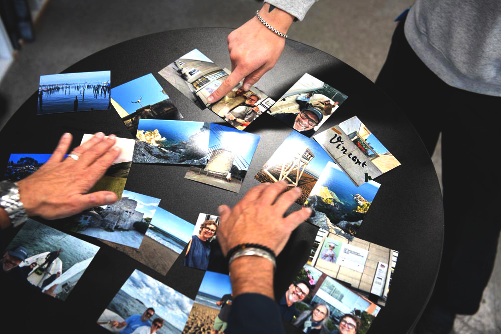 hands moving numerous small prints on a table
