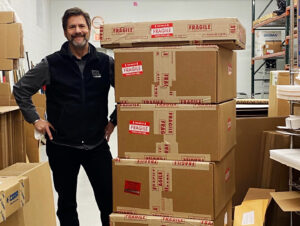 owner, Eric, with shipping boxes