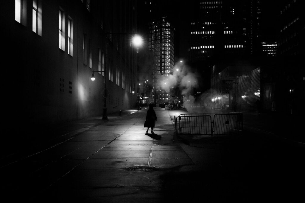 Kevin Pineda Gould photograph. Image of woman in light of street lamp at night